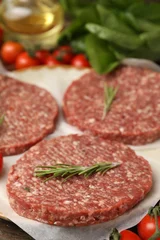 Fotobehang Natuur Park Uncooked meat patty with rosemary, tomatoes, lettuce and oil on table, closeup  © New Africa