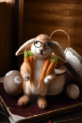 Easter decoration with handicraft felted bunny holding carrots