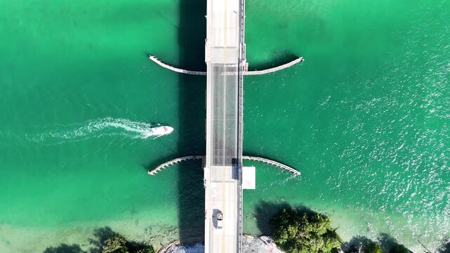 Looking down at a boat in the intracoastal passing under a drawbridge near Jupiter Inlet in Palm Beach County, Florida. 