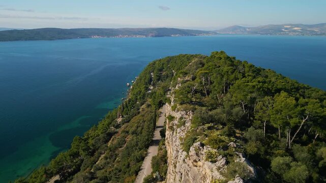 Epic aerial view of Marjan Forest Park on the Split coastline, green pine trees meeting the turquoise Adriatic sea, Croatia travel destination, 4K
