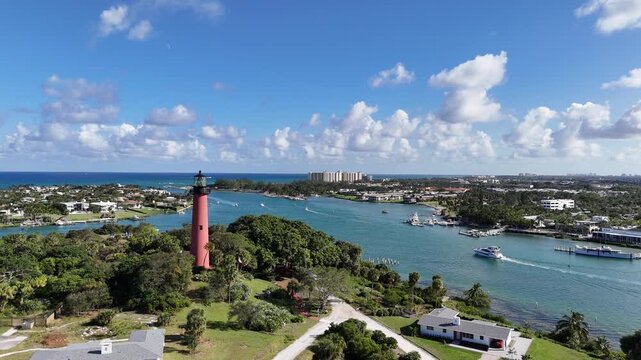 Flying by Jupiter lighthouse with boat traffic at Jupiter Inlet in Palm Beach County, Florida. 