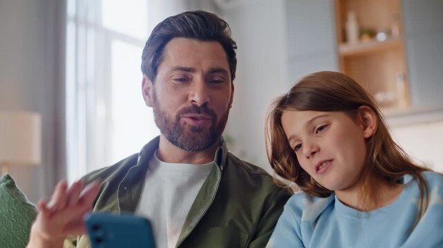 Dad daughter greeting mobile phone webcam cozy home closeup. Girl video calling