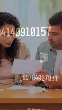 Vertical video: Couple opening envelopes causing finance overlay, using calculator checking bills