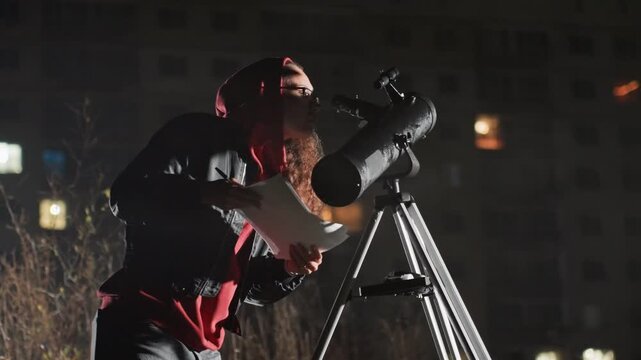 Bearded white astronomer studies star charts by telescope, annotating logbook and adjusting mount, preparing camera and eyepiece, urban skyline lights in background, deliberate focused movements,