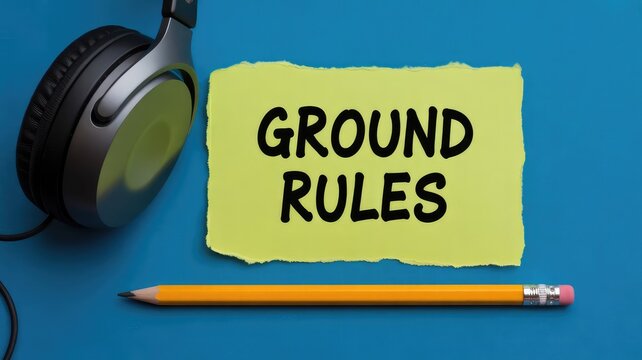 Bright yellow note displaying the essential phrase ground rules sits beside a simple yellow pencil and dark silver headphones against a vibrant blue backdrop