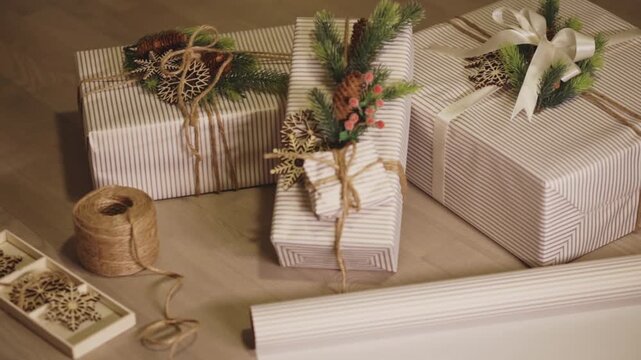 Neatly Wrapped Gifts In Striped Paper And Decorated With Christmas Ornaments. - closeup shot