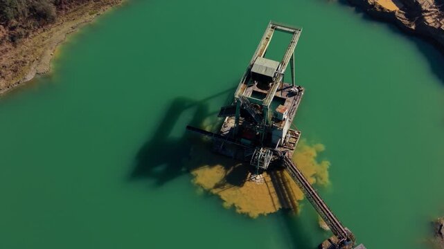 Dredging machine extracting sand from quarry lake