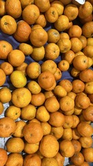 Bright Orange Mandarins Piled High on Display