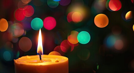 Glowing candle flame in close-up against a blurred background of colorful lights