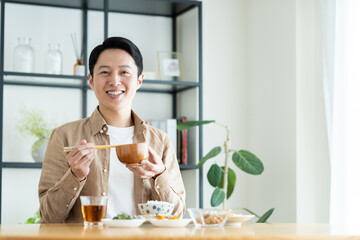 朝食で味噌汁を飲むミドルの男性