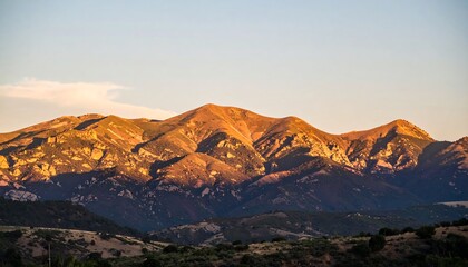 Golden Hour Light Illuminates Majestic Mountain Range at Sunset.