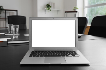 Blank laptop on table in conference hall, closeup