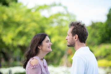 Obraz premium Affectionate man kissing woman forehead tender emotional love and trust between couple peaceful romantic gesture in outdoors. Happy couple sharing gentle intimate moment in garden.