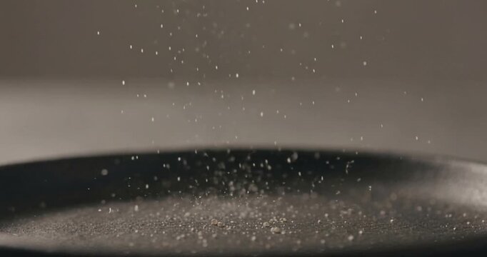 Powder falling overhead into dark round container