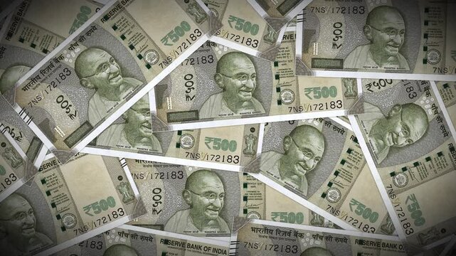 A top-down view of scattered 500 Indian Rupee banknotes with a subtle vignette. Great for documentary backgrounds or news segments about the Indian economy.