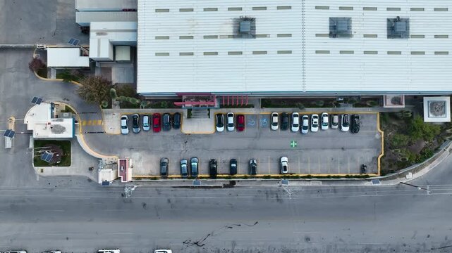 Vista a&eacute;rea de edificio industrial con estacionamiento y autom&oacute;viles