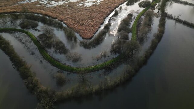 Aerial drone view of winding flooded river Derwent above flooded fields, Malton A64 Bypass, serene mood