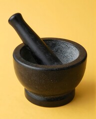 Black Mortar And Pestle Set On Yellow Background For Culinary Preparation And Cooking