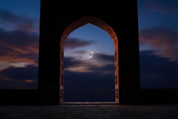 Fototapeta premium Silhouetted mosque arched entrance framing crescent moon at twilight