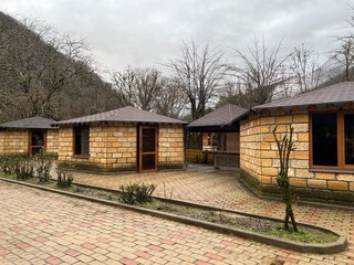 Row of yellow stone guest houses in a tourist complex in the mountains.