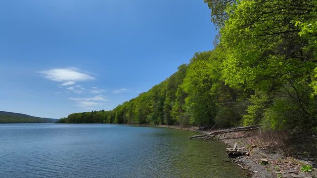 Hemlock Finger Lake in Central New York State peaceful glacier lake in springtime used for kayaking, fishing under sunny blue sky on warm day
