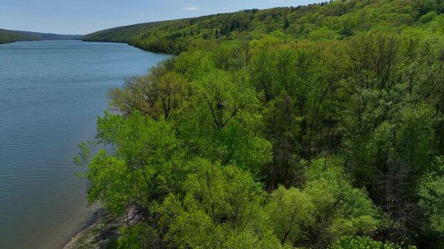 Hemlock Finger Lake in Central New York State peaceful glacier lake in springtime used for kayaking, fishing under sunny blue sky on warm day
