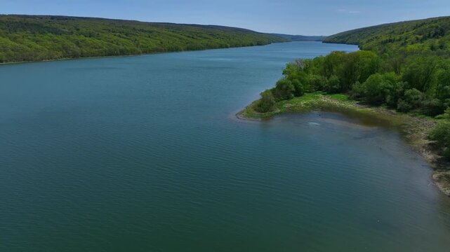 Hemlock Finger Lake in Central New York State peaceful glacier lake in springtime used for kayaking, fishing under sunny blue sky on warm day
