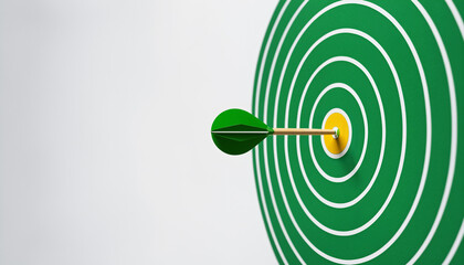 green and white circular target with yellow center bullseye and green dart hitting the mark for successful business strategy and goal achievement planning.