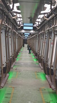 Inside view of a modern continuous metro train curving into perspective as it navigates a turn, creating a hypnotic and endless tunnel-like visual effect.