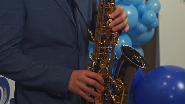 Close-up video of a saxophonist's hands skillfully pressing the keys of the instrument, focusing on the musician's technique and the gleaming saxophone.