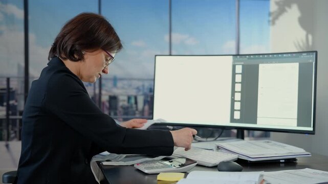 Wide view of business woman accountant making calculations financial data sheet with calculator. Business and financial concept.