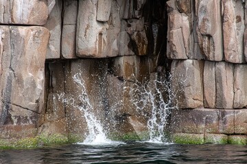 Water splashes from a rocky cliff face