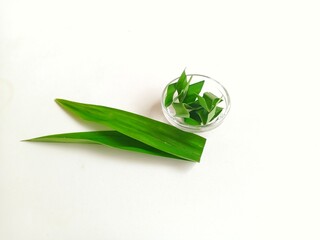 Fototapeta premium Close up of pandan or pandanus leaf slices in bowl isolated on white background