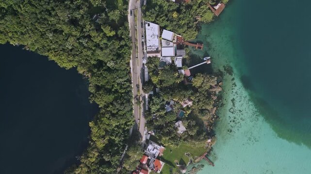 Drone captures Bacalar cenotes and resort along the ocean. Enjoy the vibrant colors of the water and lush surroundings in this aerial perspective revealing the natural beauty of Mexico.