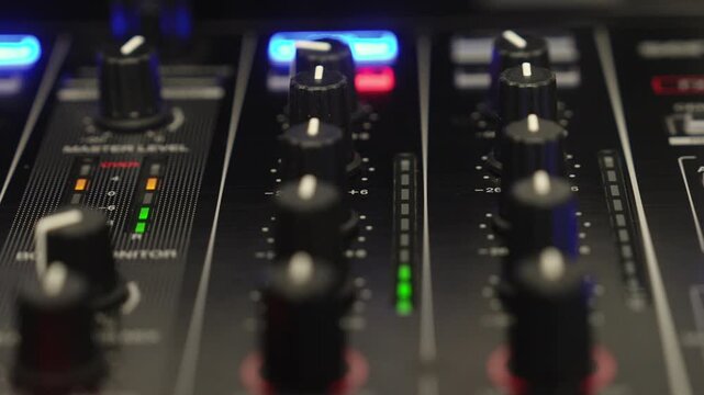 Close up of a DJ mixer channel meter displaying clean and balanced audio levels in a club or studio environment with professional equipment.