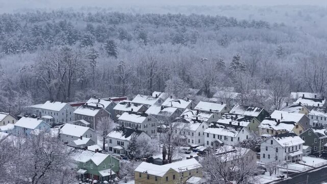 New England suburb with snow falling on rooftop condos town homes at forest edge