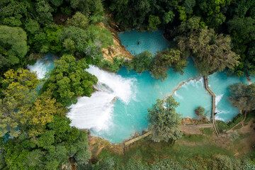 Cascada de Minas Viejas shows natural turquoise water surrounded by tropical plants in Huasteca Potosina region