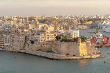 Obraz premium Stunning aerial view of Senglea's fortifications and Gardjola Gardens in Malta at sunset. Perfect for Mediterranean travel, maritime industry, and heritage tourism marketing.
