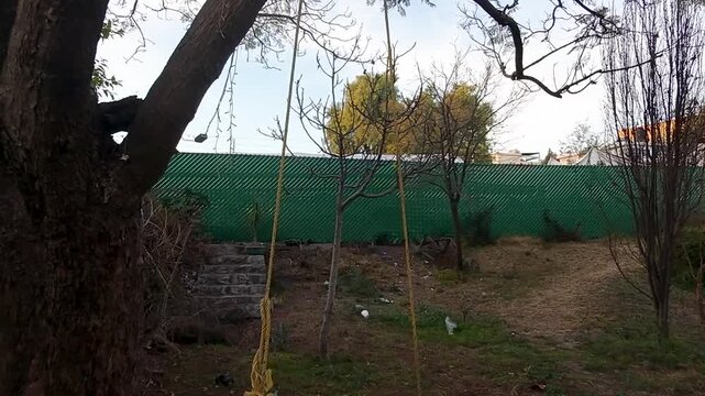 Imagen de un drone pasando por en medio de un columpio 