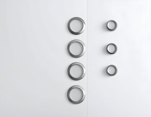 Minimalist image of round metallic fixtures embedded in a smooth white vertical surface, arranged in columns