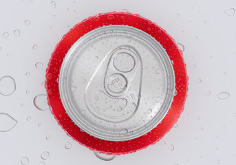 Top view. A red aluminum soda can covered in condensation, resting on a surface with scattered water drops