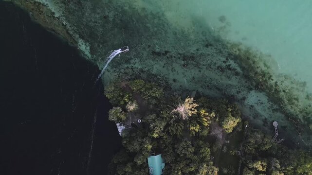 Discover stunning Bacalar cenotes captured from a drone. Boats glide through clear waters, showcasing the natural beauty of this destination in Mexico. Enjoy the vibrant colors of the landscape.