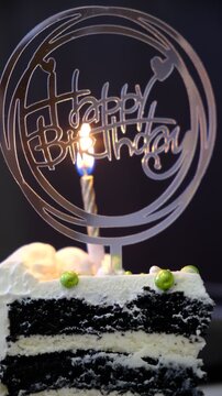 Happy Birthday text. Birthday cake with white cream cheese, cake tier. Delicate lambeth style birthday cake with white cream cheese, festive background with string lights. Candlelight