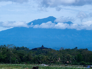Aerial view of Borobudur Temple in Central Java, Indonesia, with Merapi volcano in the background. UNESCO World Heritage Site, culture, history, and travel themes © Wang