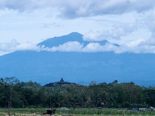 Aerial view of Borobudur Temple in Central Java, Indonesia, with Merapi volcano in the background. UNESCO World Heritage Site, culture, history, and travel themes © Wang