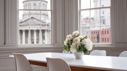 Elegant dining table with white flowers and cityscape view through windows