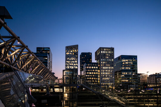 Modern architecture defines the downtown city skyline at dusk in Oslo Norway with bridge and towers rising above the metropolitan capital