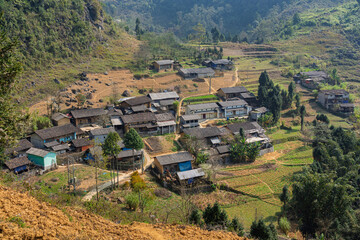Rural village nestled among terraced fields and mountain slopes.