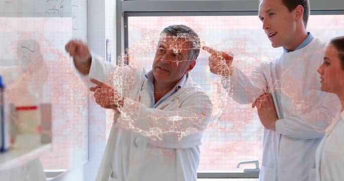 Lead scientist pointing at reagent shelf and activating hologram while guiding junior team in lab