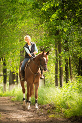 The girl rides a horsein the spring forest.